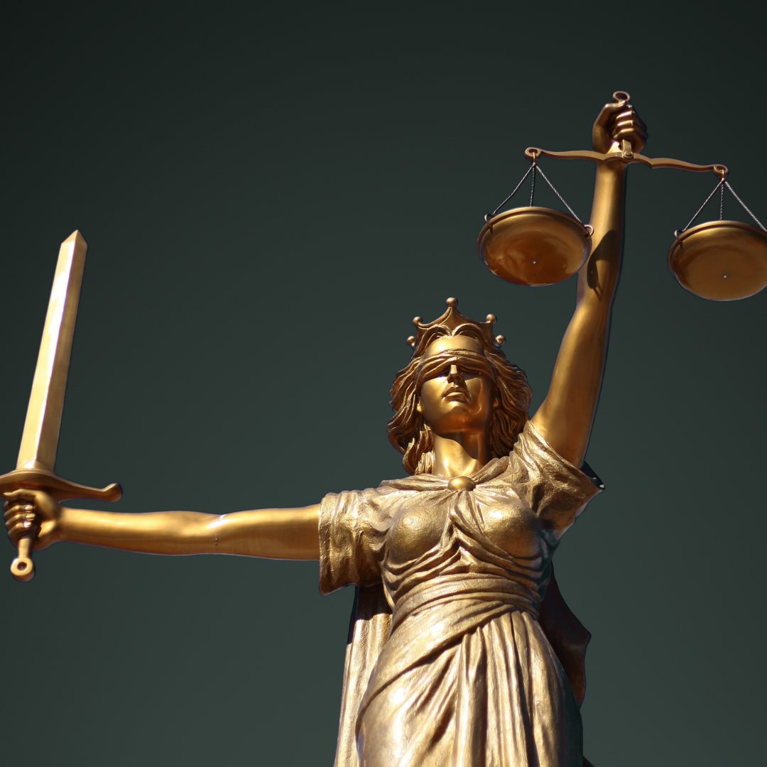Golden statue of Lady Justice holding scales and a sword